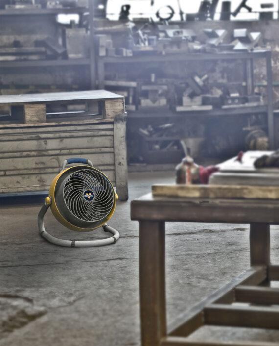 Yellow 293 Heavy Duty Large Air Circulator in a garage on the floor pointed at a workbench