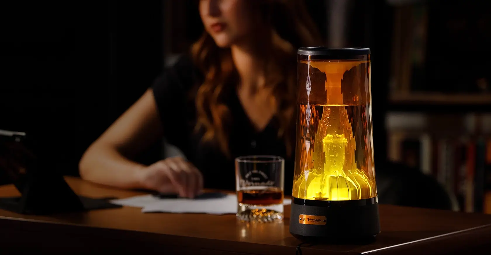 Lucerna 1 Humidifier on a desk. There is a woman sitting at the desk using a tablet but is out of focus