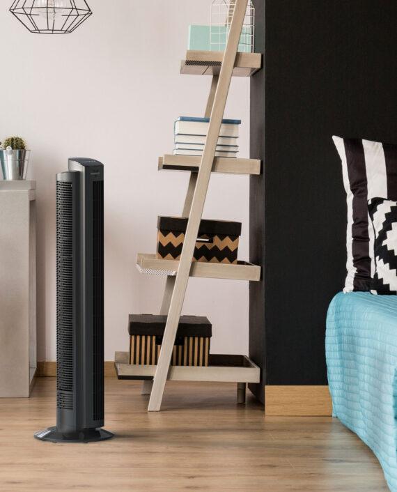 Lifestyle of Vornado OZI42 42" Oscillating Tower Circulator on wood floor in a bedroom