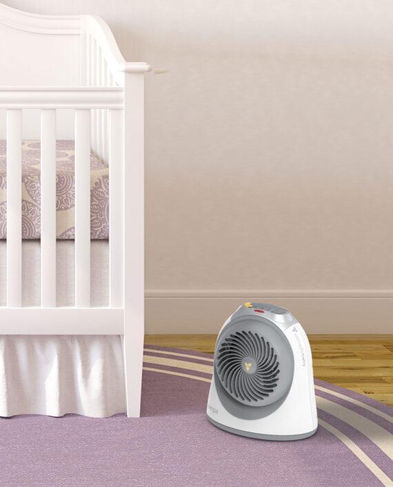 Lifestyle of a white Tempa small nursery heater on a purple rug neat a white crib